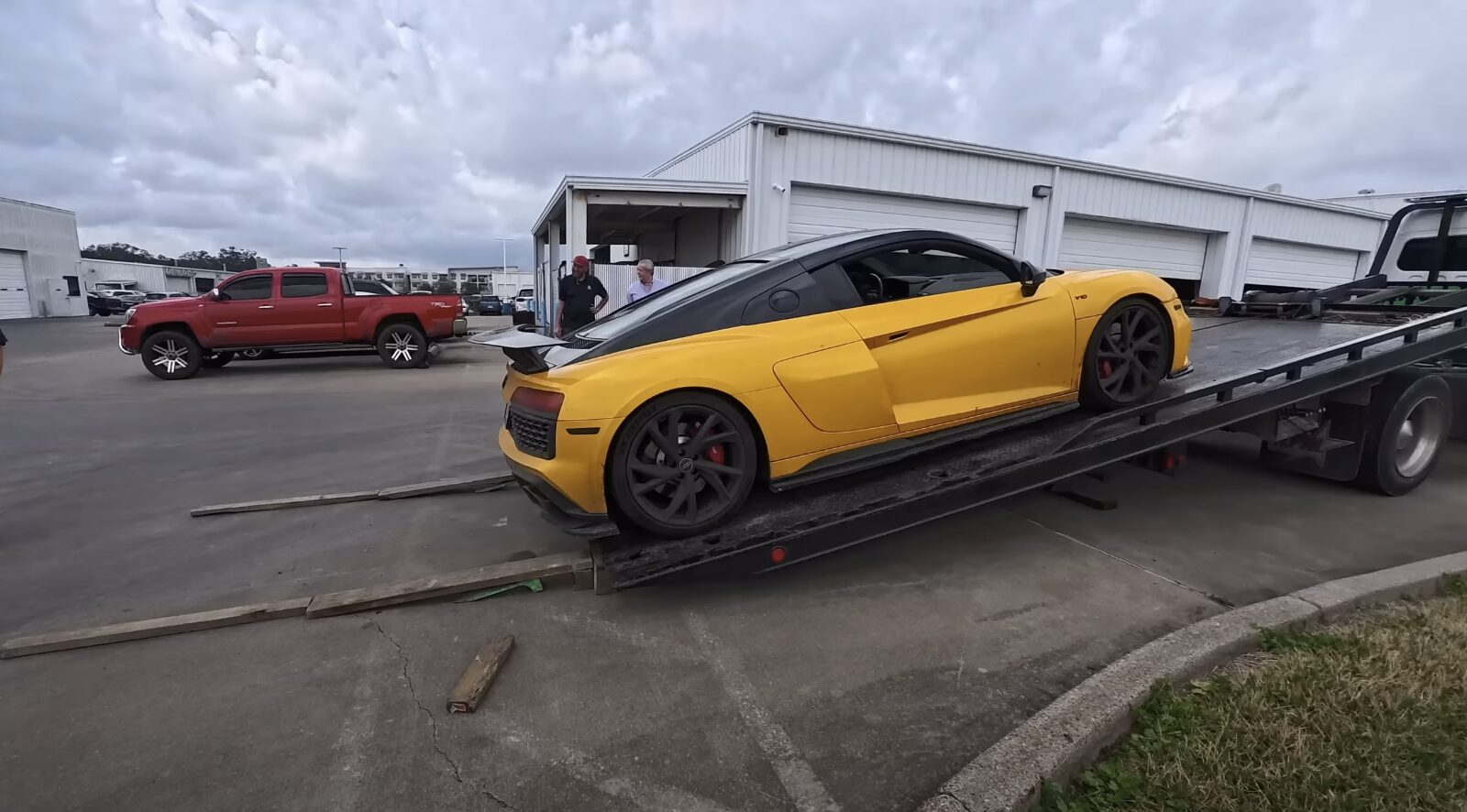 Luxury sports car being professionally loaded onto flatbed truck